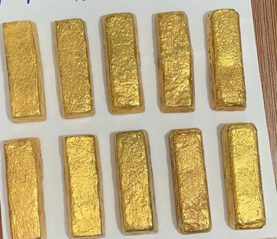Gold bars arranged on a white surface